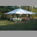 Anchor Industries 20x30 All Purpose Canopy with several tables, chairs and disposable plastic table covers.